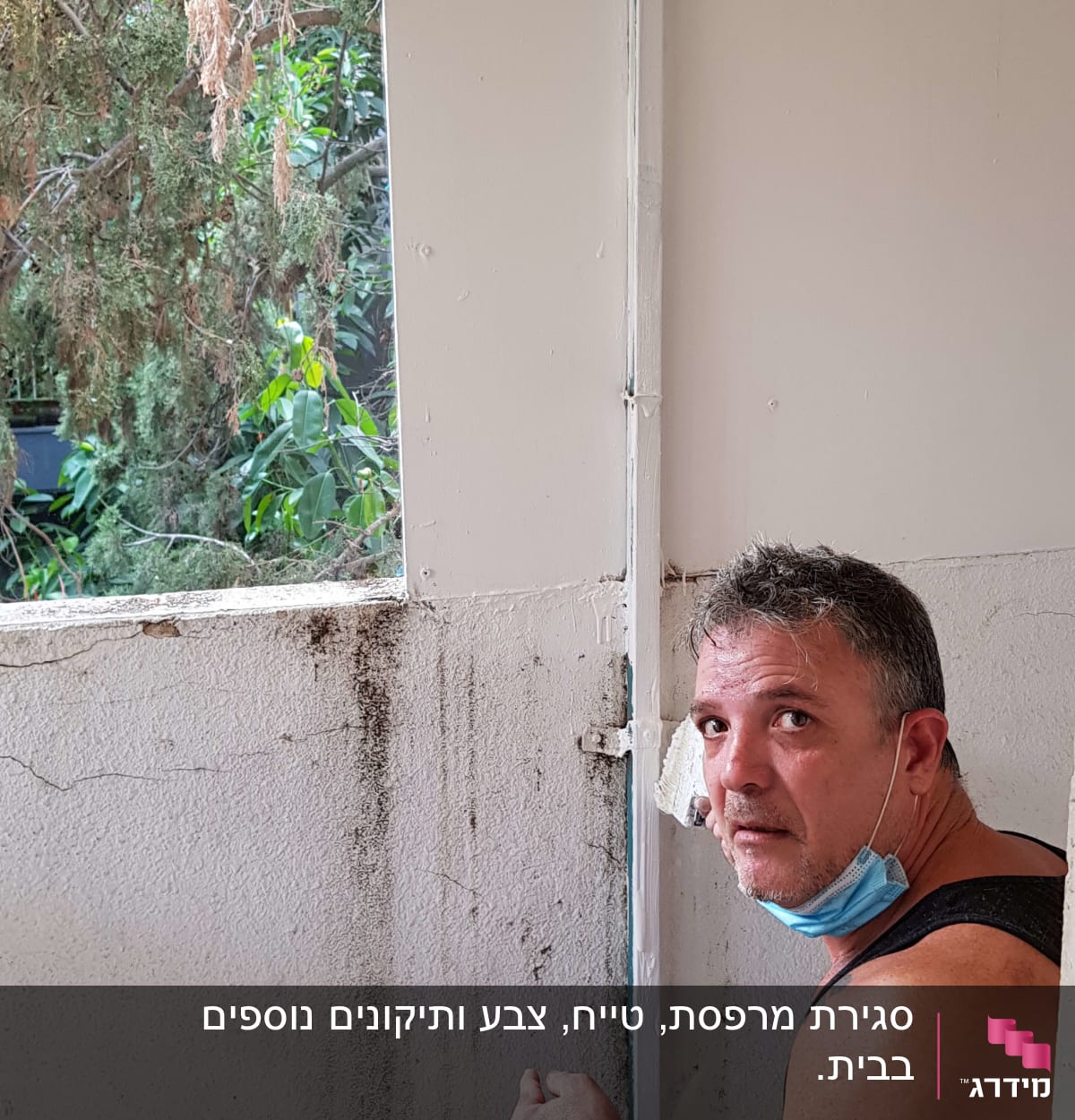 אדם עם מסכה ליד קיר מתקלף